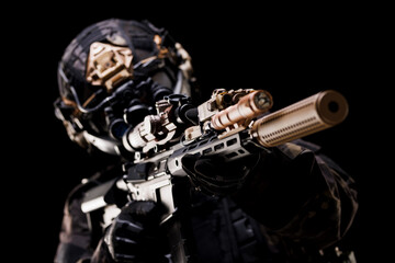 Special Forces Operator Aiming Rifle with Tactical Gear in Low Light