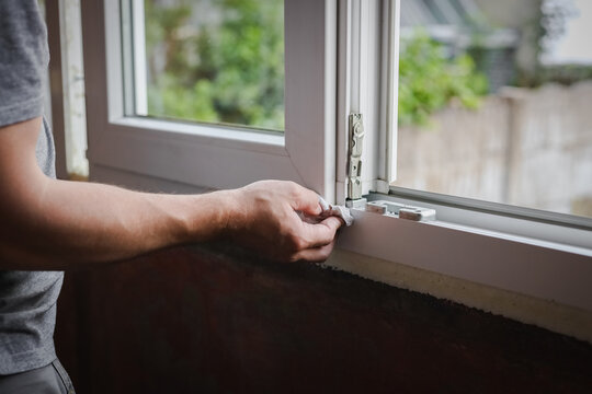 One young worker wipes the window frames with a napkin.