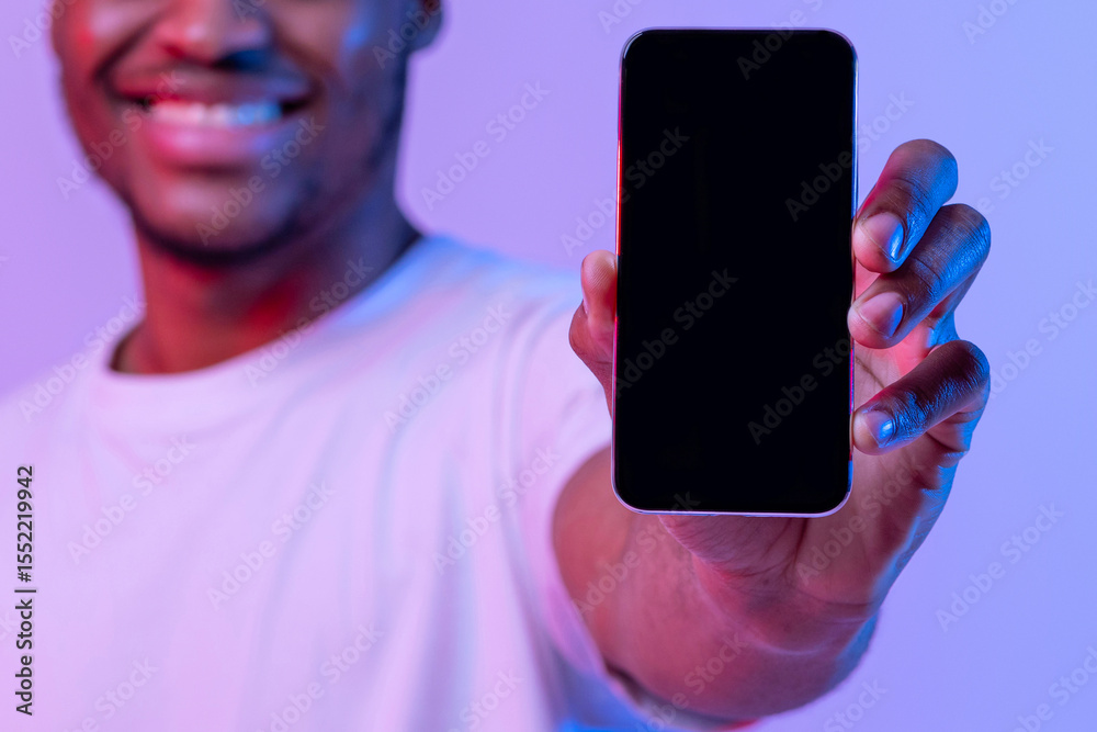 Poster cheerful african american guy showing black smartphone screen with copy space for your app design, r