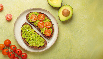 Two slices of whole rye bread are topped with mashed avocado, green peas, cherry tomatoes, and sesame seeds, a healthy and vibrant breakfast or snack option