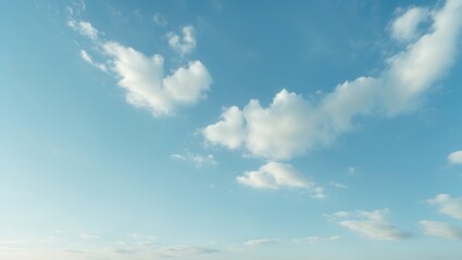 Obraz premium A calming image of a soft blue sky with gentle white clouds scattered across, capturing the peacefulness and tranquility of a calm day.