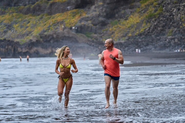 Couple jogging on volcanic beach