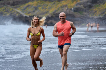 Couple jogging on volcanic beach