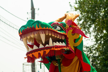 Chinese dragon head with ribbons at street celebration procession