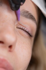 The process of professional eyelash lamination in a salon. 