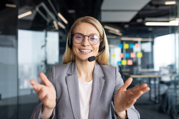 A friendly customer service representative wearing a headset in a modern office environment,...