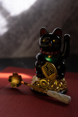 Maneki-neko surrounded by red decorations – symbol of Chinese prosperity