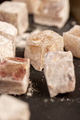 cubes of sweet Turkish delight with the addition of dried red berries in powdered sugar