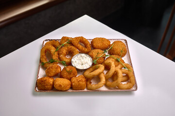 Fried appetizer platter with onion rings and sauce