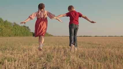 Friends run together raising their hands, dream is to fly to travel. Kids fly, running. Children boy, girl play, park. Creative imagination of children, concept of active play, nature. Family holiday