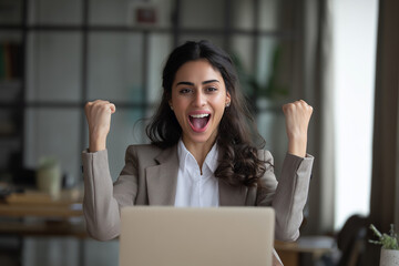 Woman celebrates triumph with ecstatic joy at her laptop