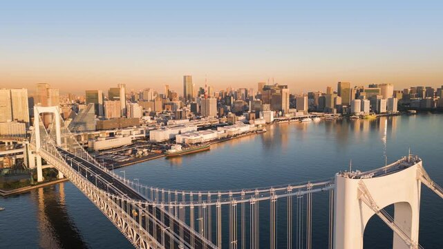 tokyo city skyline aerial view drone at sunrise seen from the water bay with rainbow bridge landmark in the foreground
