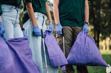 Volunteers holding trash bags picking up trash