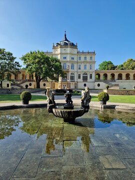 State Chateau Ploskovice in the Czech Republic illuminated by evening light, with a garden fountain in the foreground. Historic architecture and peaceful park atmosphere.