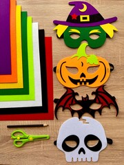 Halloween. DIY Felt Halloween Masks. Felt masks and felt sheets are lying on the table. Set of Various Masks, monsters, Pumpkin, Devil, Witch, Skeleton, Bat, DIY Toys, Dress Up Mask, Game Accessories.