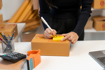 Woman Writing on Shipping Box for Small Business