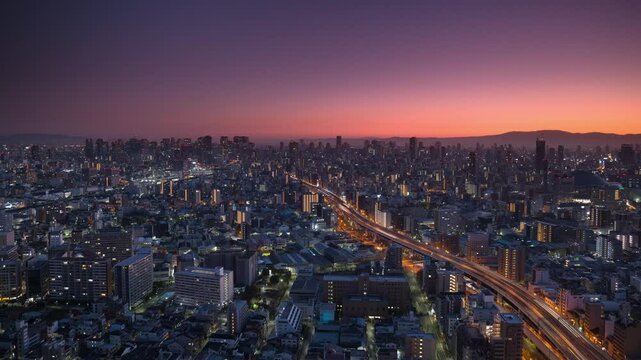 osaka city slyline aerial shot time lapse from night to day,high view of metropolis cityscape at sunrise - Powered by Adobe