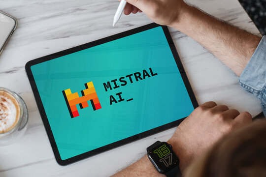Designer using tablet showing mistral ai logo in a modern office