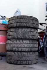 Set of used summer or winter tires after replacement in a home workshop. Car wheels with tread in a service center after the season