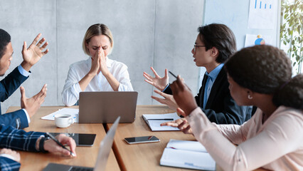 Aggressive Colleagues Shouting At Unhappy Victimized Business Lady Sitting At Desk In Modern...