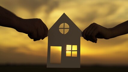 Dream to buy house. Home for children and parents, Family hands are holding paper house at sunset, sun is shining through window. Symbol of house, happiness. Concept of building house for family.