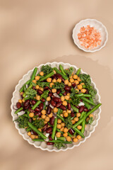 Fresh mixed salad of beans and chickpeas on a beige background. Vegetarian dishes 