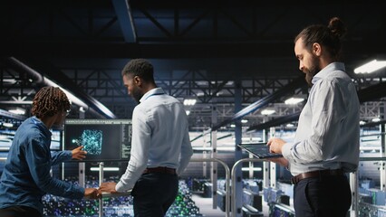 Programmers on data center industrial platform checking code on tablet, doing software updates....
