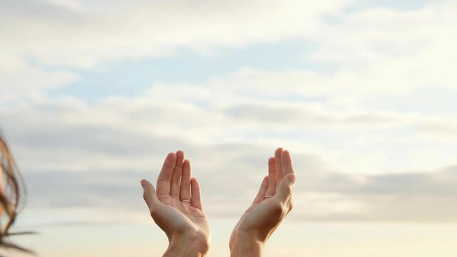 Woman's hands raised towards sky, expressing prayer or hope