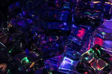 Transparent ice cubes illuminated by vibrant LED lights in blue, purple, green, and pink hues,...