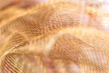 Golden Mesh Fabric in Motion with Intricate Patterns and Shimmering Metallic Texture in Dynamic...