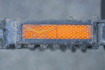 one black bike dirty pedal with plastic orange reflector on bike in the street
