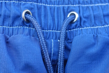 part of blue fabric sweatpants with elastic and long laces
