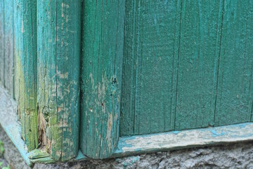 green wooden texture from wide old worn planks in the wall of the fence in the street