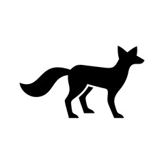 Silhouette of a fox standing with its tail curved upwards and pointy ears looking alert and watchful
