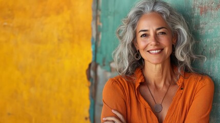 Fototapeta premium A smiling gray-haired woman poses against a vibrant backdrop, radiating warmth and confidence while reflecting a sense of authenticity in a contemporary artistic environment.