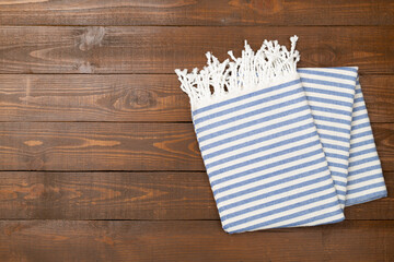 Folded blue beach towel on wooden background,top view