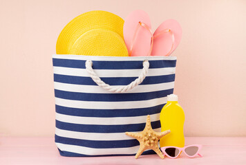 Blue beach bag with summer accessories on wooden table