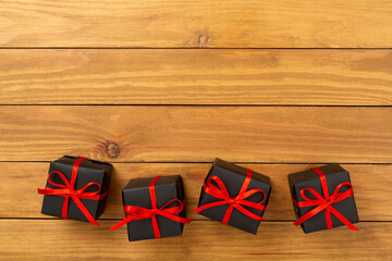 Black gift boxes on wooden background, top view. Black Friday concept