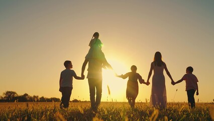 Parents with children on walk. Big family kids. Group of people in nature. Active family with children go across grassy field in autumn. Daughter on shoulders of Dad, mom son walk hand in hand outdoor