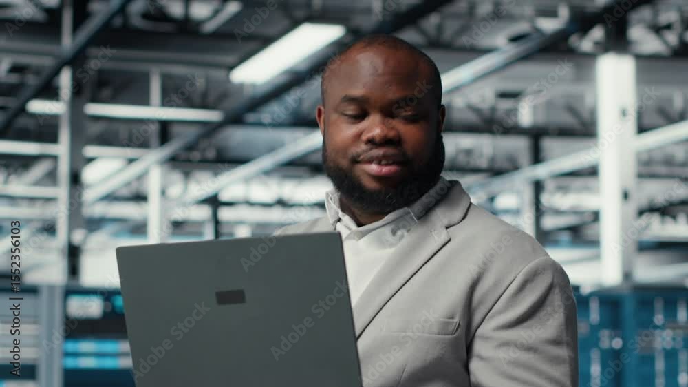 Poster computer scientist using laptop in data center, managing server virtualization. african american man