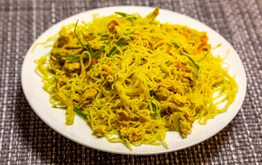 Traditional Asian food rice noodles known as bifum, with chicken, vegetables and curry