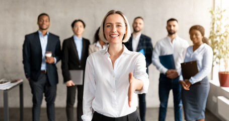 Obraz premium Cheerful Businesswoman Stretching Hand For Handshake Greeting To Camera Making Career Offer Standing In Modern Office. Recruitment And Employment, Human Resources, Join Our Team Concept