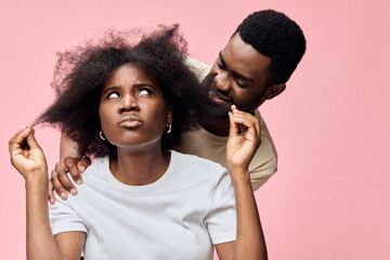 A young African couple expresses frustration and curiosity, with the woman showing concern about...