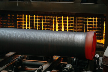 Freshly cast red hot iron pipe at the foundry, new pipe is cooling down
