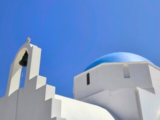 Closeup view of the Holy Chapel of Agia Marina in Antiparos, Greece – A beautiful whitewashed Orthodox church with a classic Cycladic blue dome, welcoming visitors at the island’s picturesque port.