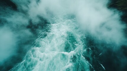 An aerial view capturing the beauty of turbulent ocean waves merging with mist, creating a dramatic and serene atmosphere perfect for nature-related stock images.