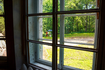 View from a wooden-framed window in an old house onto the surrounding area