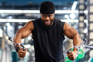 Motivated young black sportsman having workout on crossover machine. Handsome african american man...