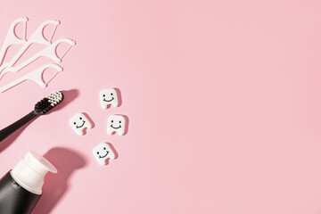 Different oral care products and teeth figures on pink background, flat lay. Space for text