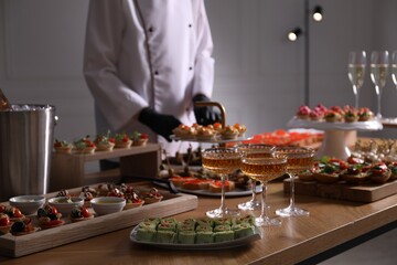 Chef arranging appetizers on buffet table, selective focus